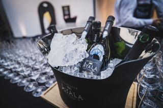 Mehrere Champagnerflaschen unterschiedlicher Preisklassen nebeneinander im Regal